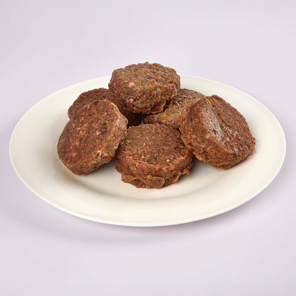 Six Senior's Club raw dog food patties on a white plate from LUNA & me