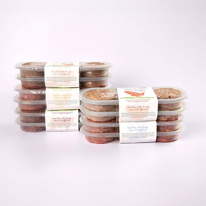 Five stacked plastic containers filled with LUNA & me Growing Up Box raw dog food patties