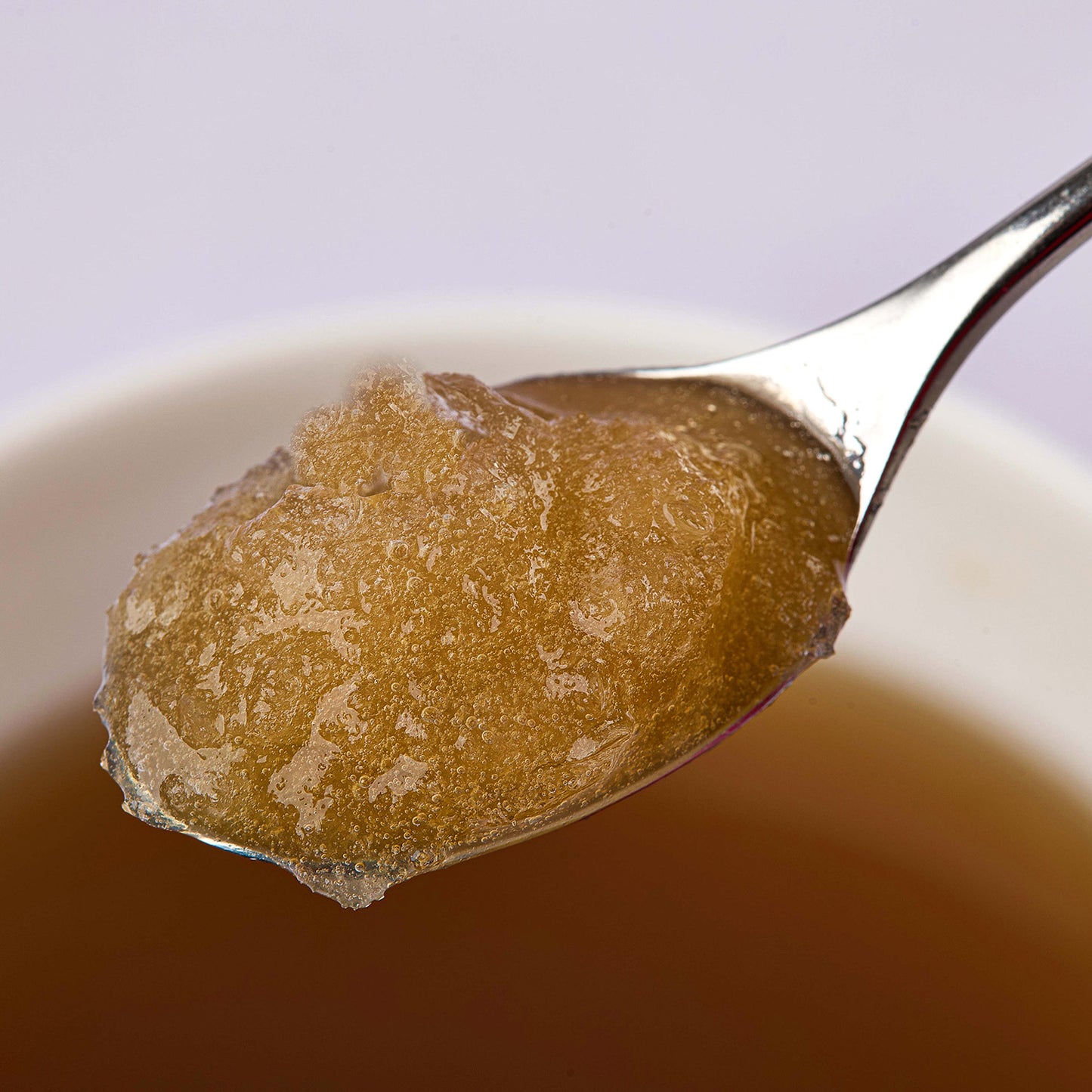 A spoon lifting a scoop of LUNA & me bone broth from a bowl: a tasty treat for dogs