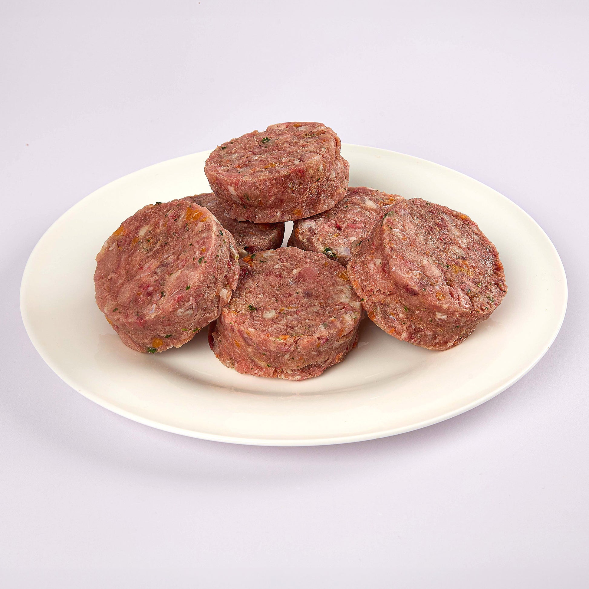 Six LUNA & me Adult Rabbit raw dog food patties on a white plate